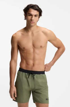 Badeshorts mit kontrastfarbenem Logo und Paspelierung