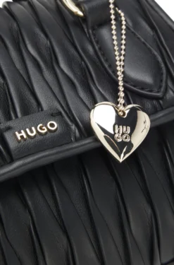 Handtasche aus Kunstleder mit Matelassé-Struktur und metallenem Herzanhänger