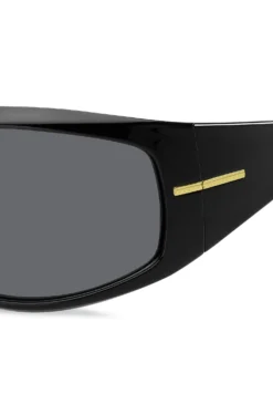 Schwarze Sonnenbrille im Masken-Stil mit goldfarbenen Metalldetails